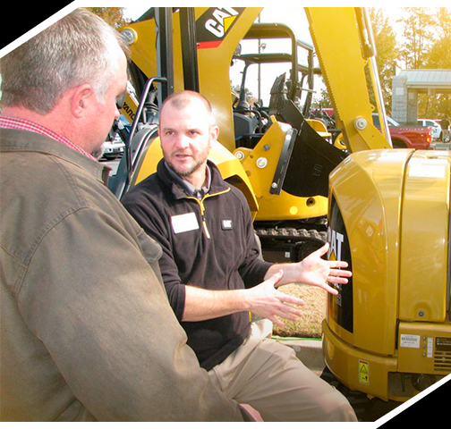 dos hombres hablando de un Yancey Caterpillar tractor